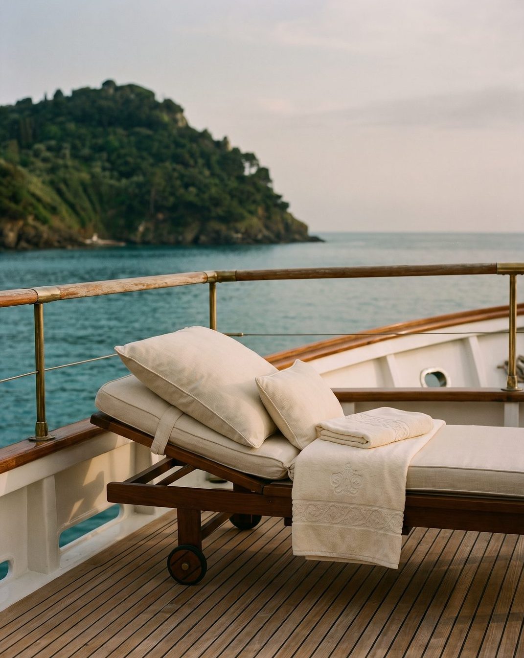 The teak deck of a motor yacht in a secluded bay